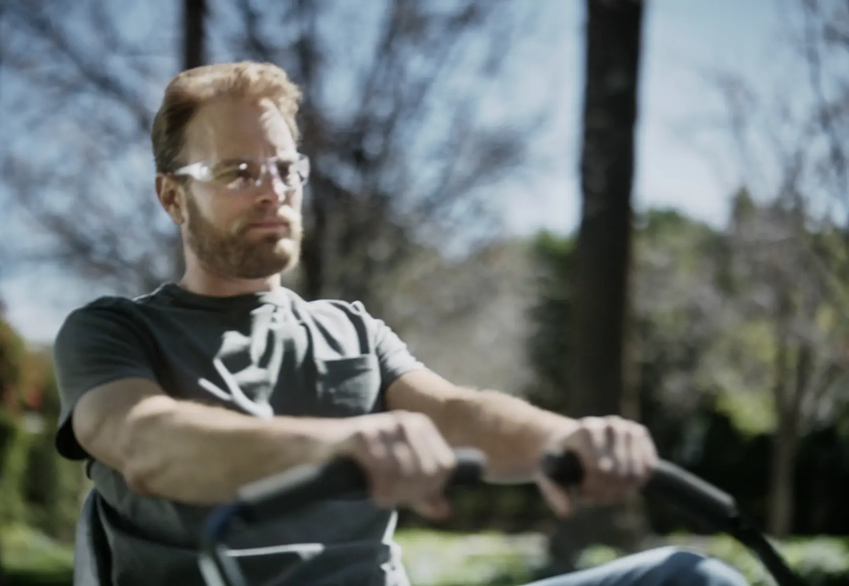 Close up of person using 22 h p 46 inch zero turn riding mower to mow the lawn.