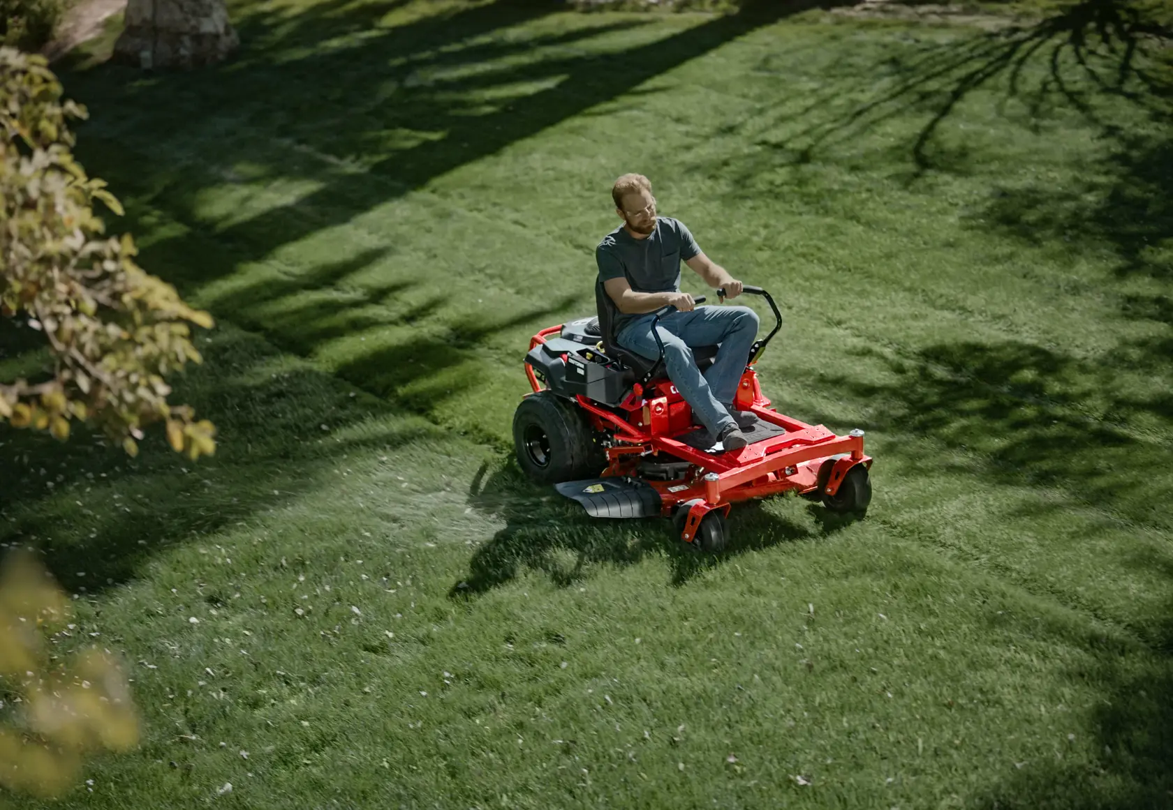 Top view of 22 h p 46 inch zero turn riding mower being used by a person to mow the lawn.