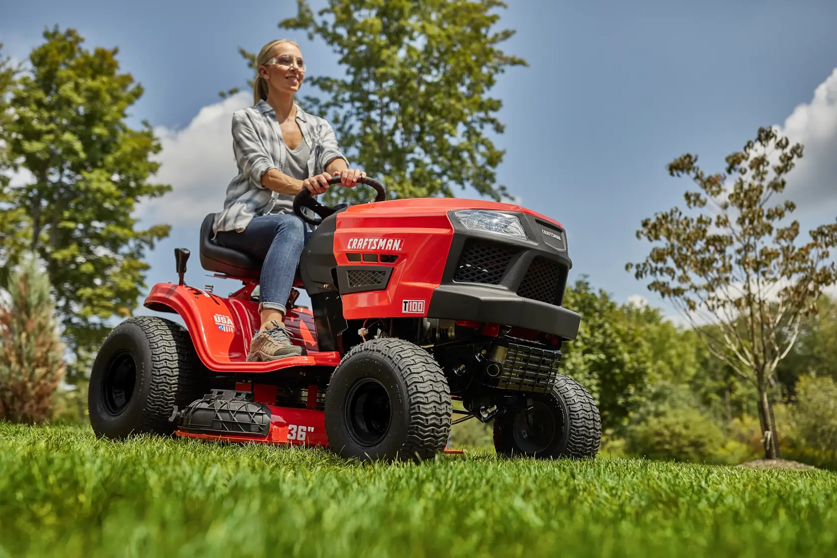 CRAFTSMAN T100 36 In. 11.5 Hp* Gear Drive Riding Mower mowing in yard female wearing jeans and plaid