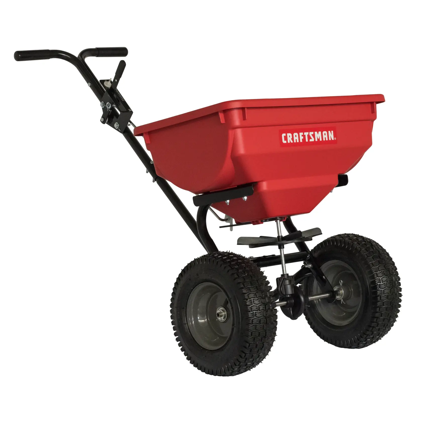 A red Craftsman push spreader with a large hopper, sturdy black handle, and two robust wheels, designed for evenly distributing materials like seed or fertilizer on lawns.