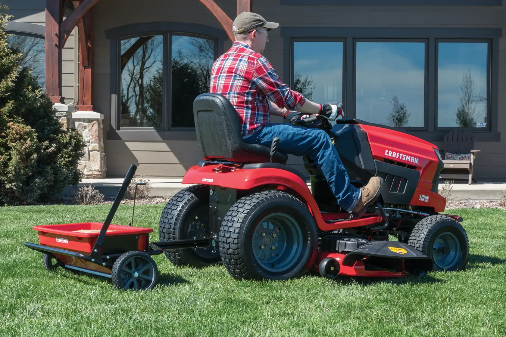 100 pounds aerator drop spreader combo being used to aerate lawn by person.
