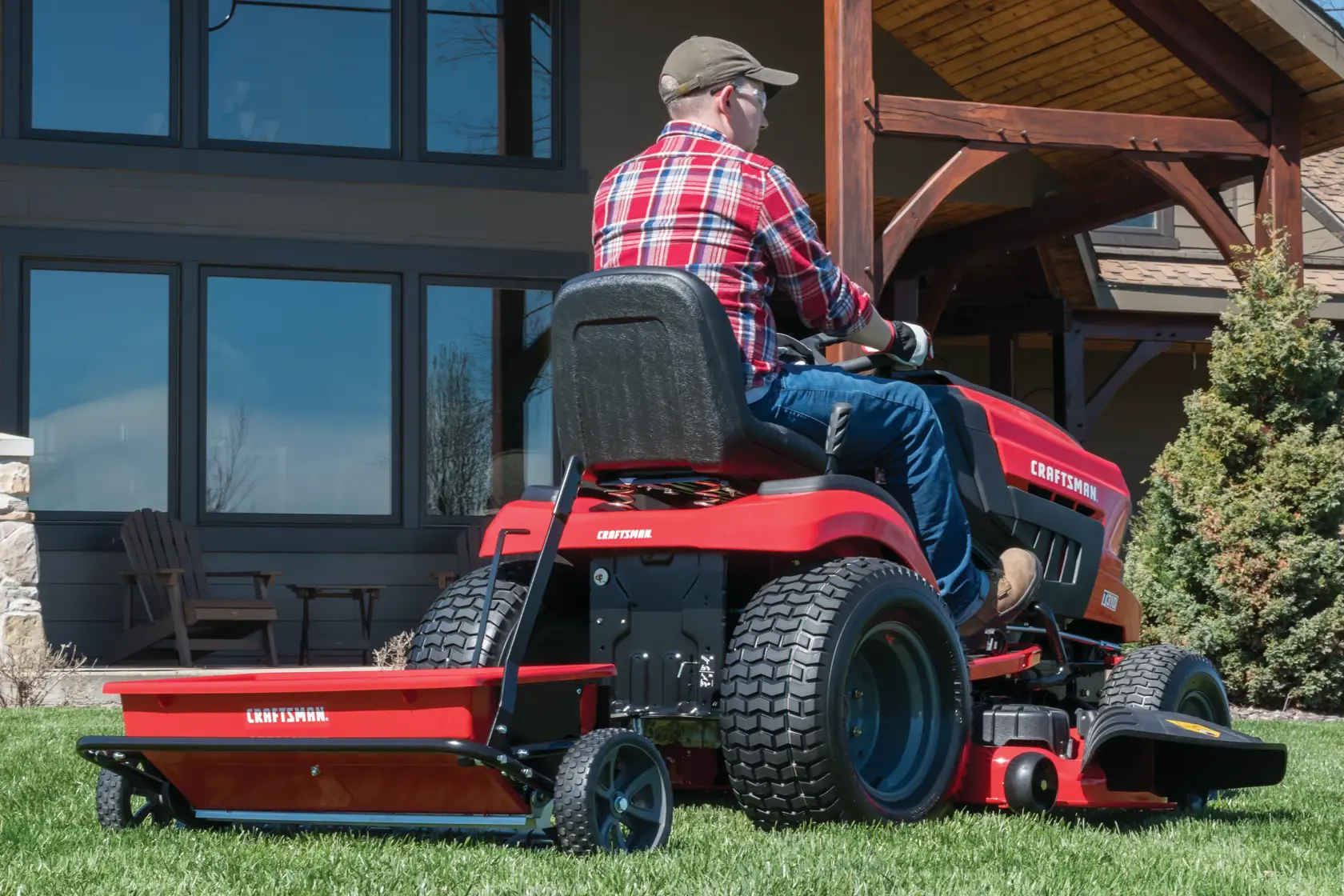 100 pounds aerator drop spreader combo being used to spread seeds in lawn by person.