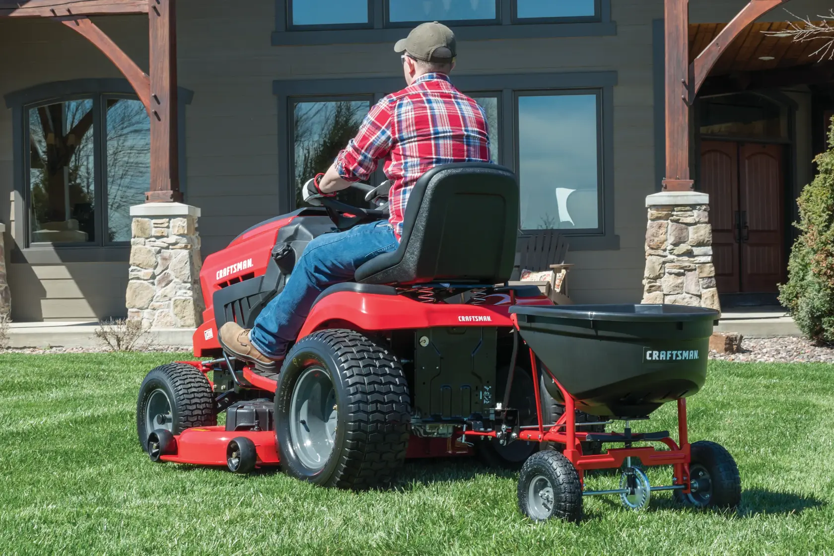 110 pounds tow broadcast spreader being used to spread fertilizer in the lawn.