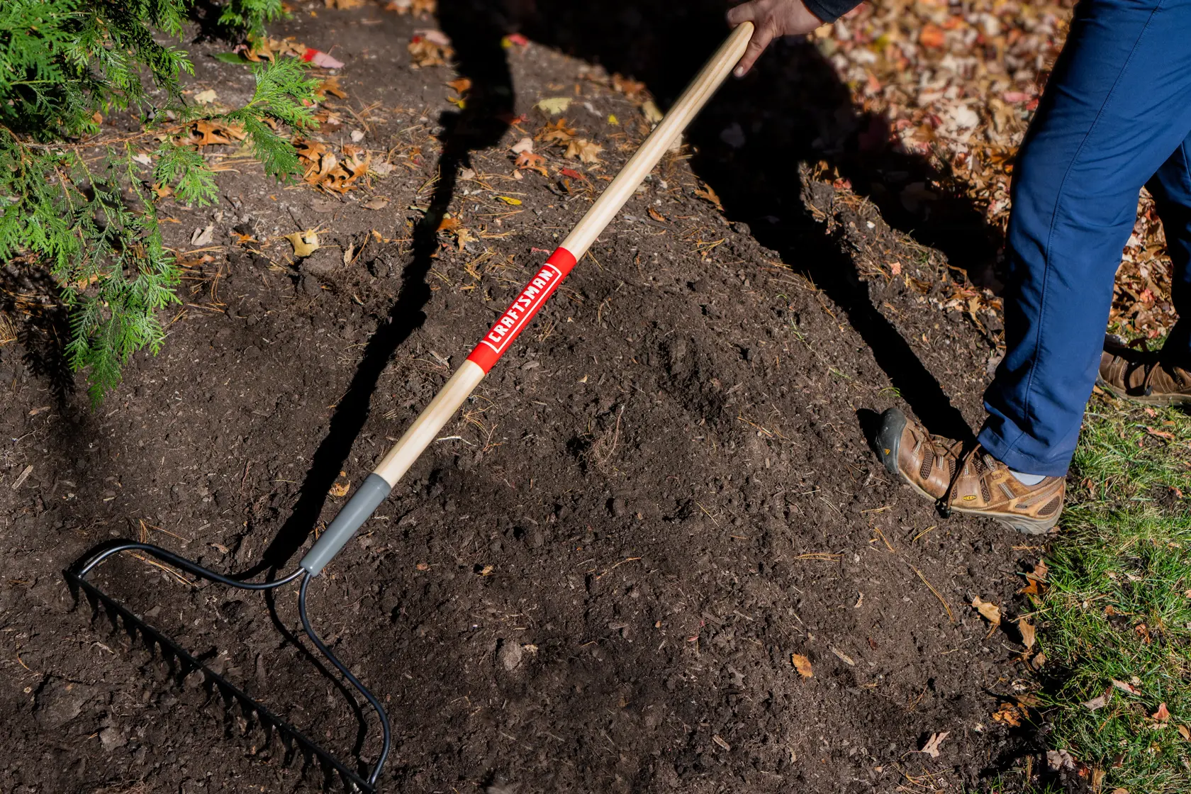 Long Handle 16 Tine Steel Garden Soil Rake with wood handle and cushion grip, in action raking
