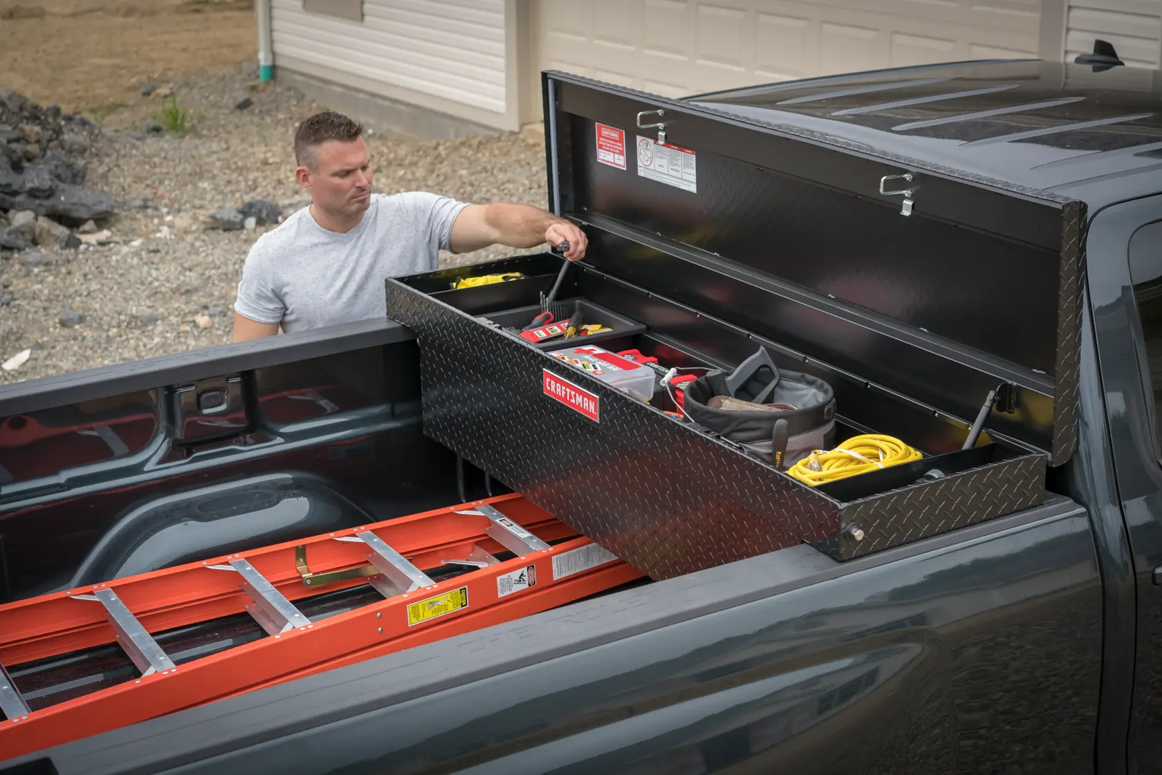 Craftsman CMXTBAK1005301 truck toolbox on pickup bed, open with hand tools and accessories organized inside.