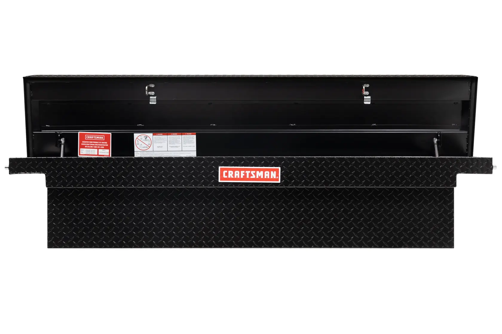 Open black CRAFTSMAN truck tool box with diamond plate pattern, showing interior and warning labels.