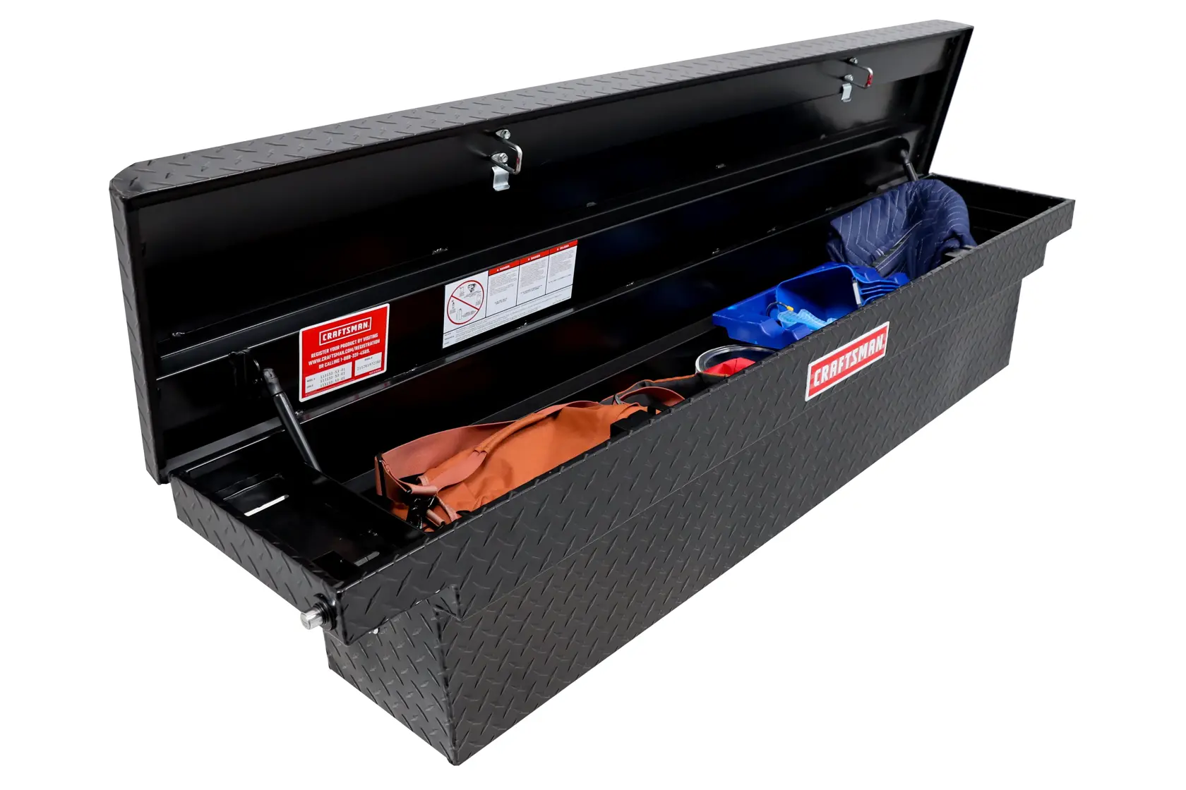 Open CRAFTSMAN black truck tool box with diamond pattern, storing various items inside on a white background.