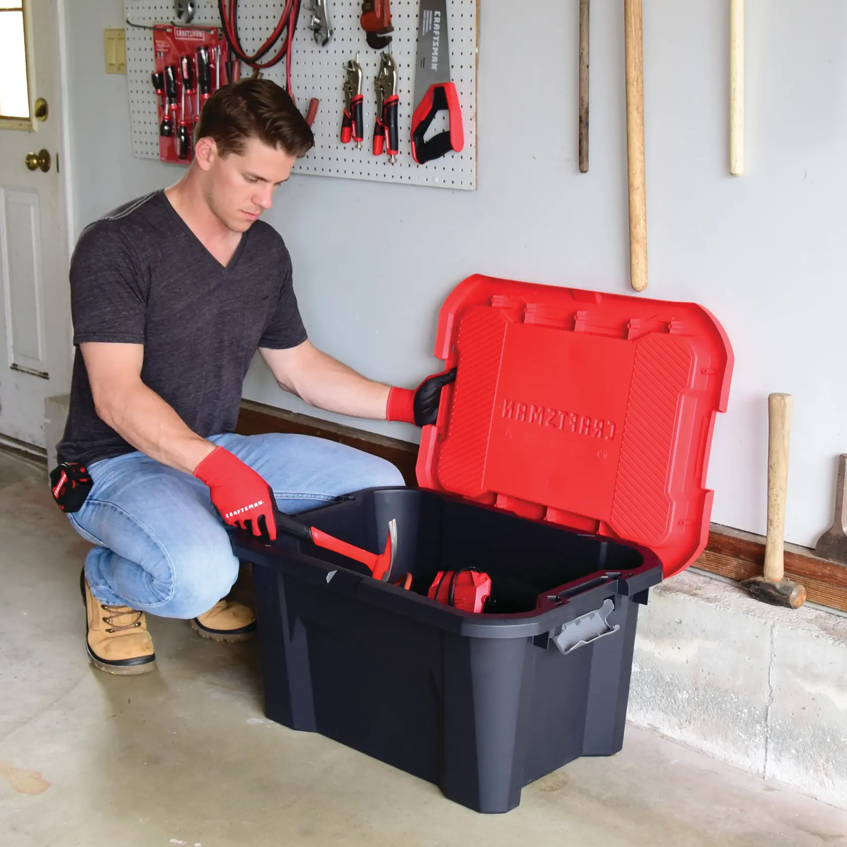 20 Gallon latching tote being used by a person to store tools.