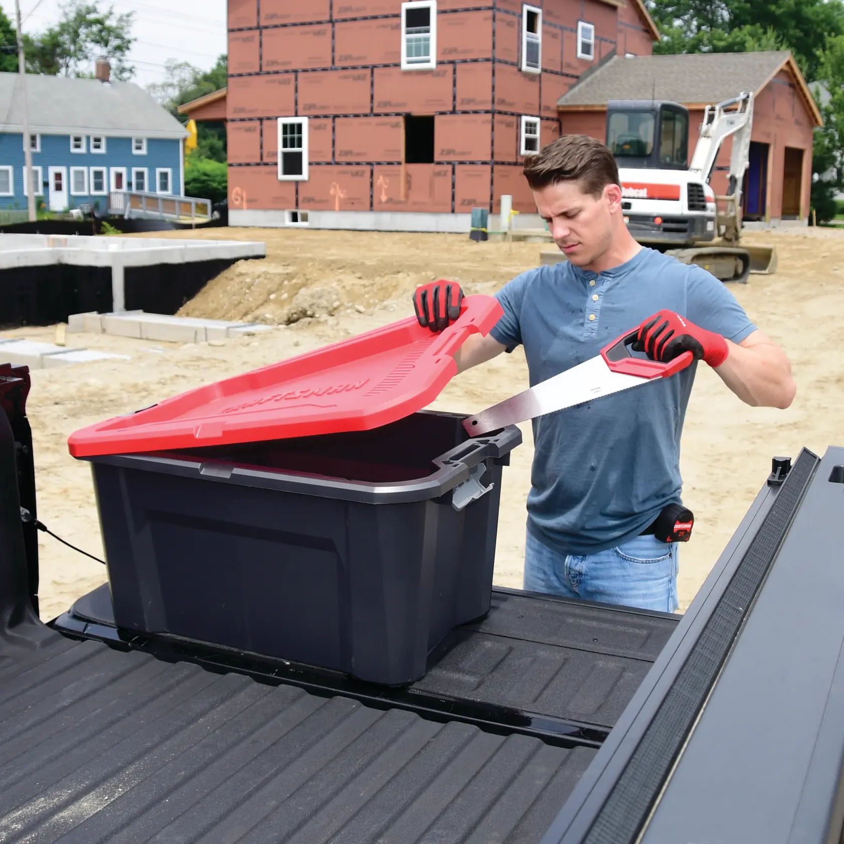 30 Gallon latching tote being used by a person to store tools.