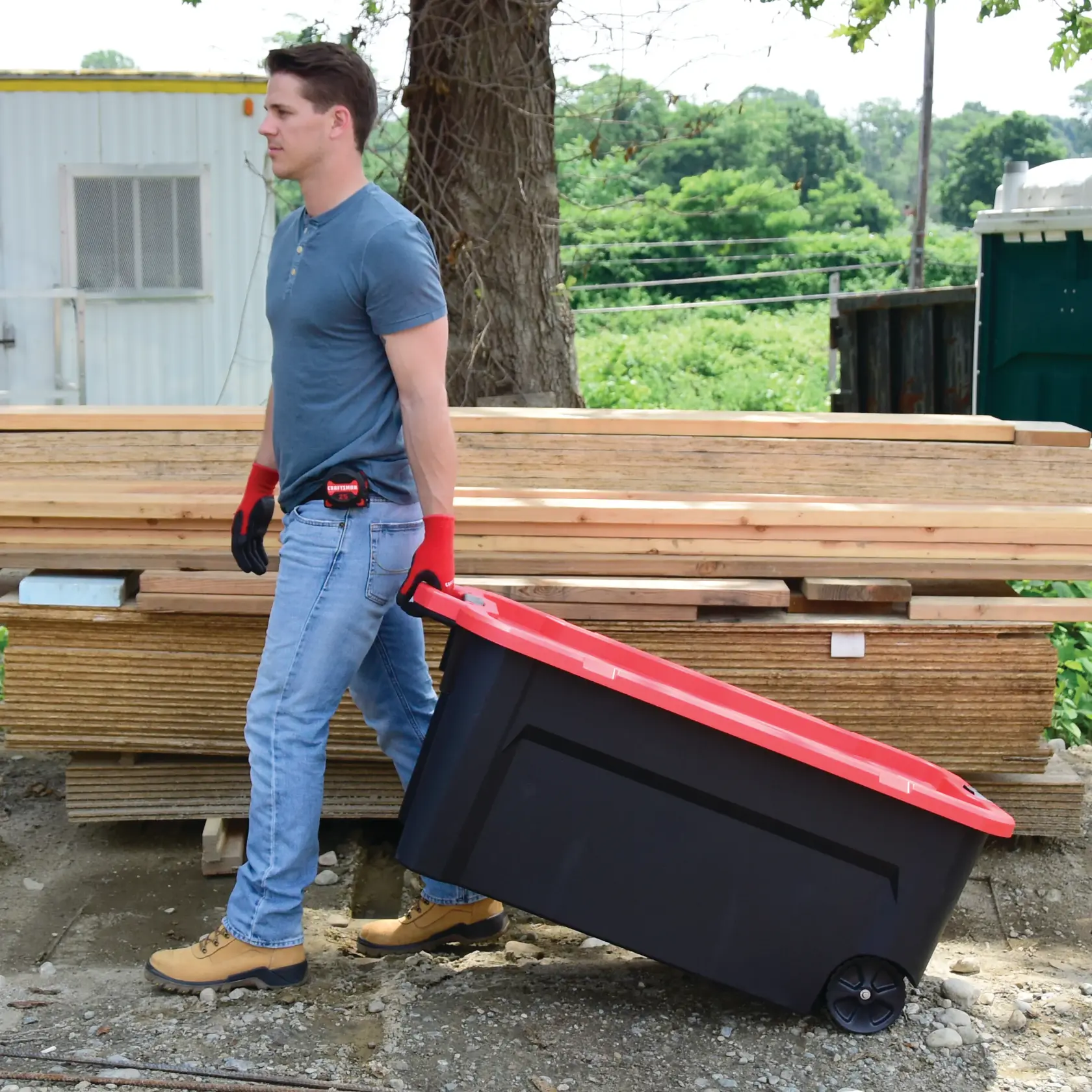 Closeup of 50 Gallon latching tote being carried by a person.