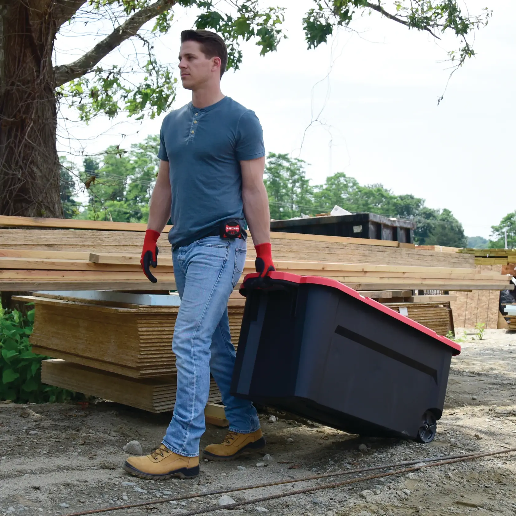 Overhead view of 50 Gallon latching tote being carried by a person.
