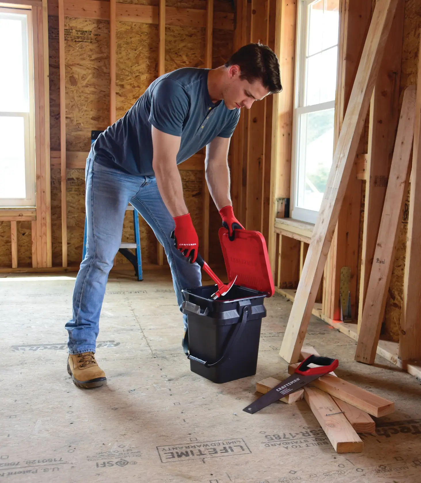 5 Gallon latching bucket being used by a person to store tools.
