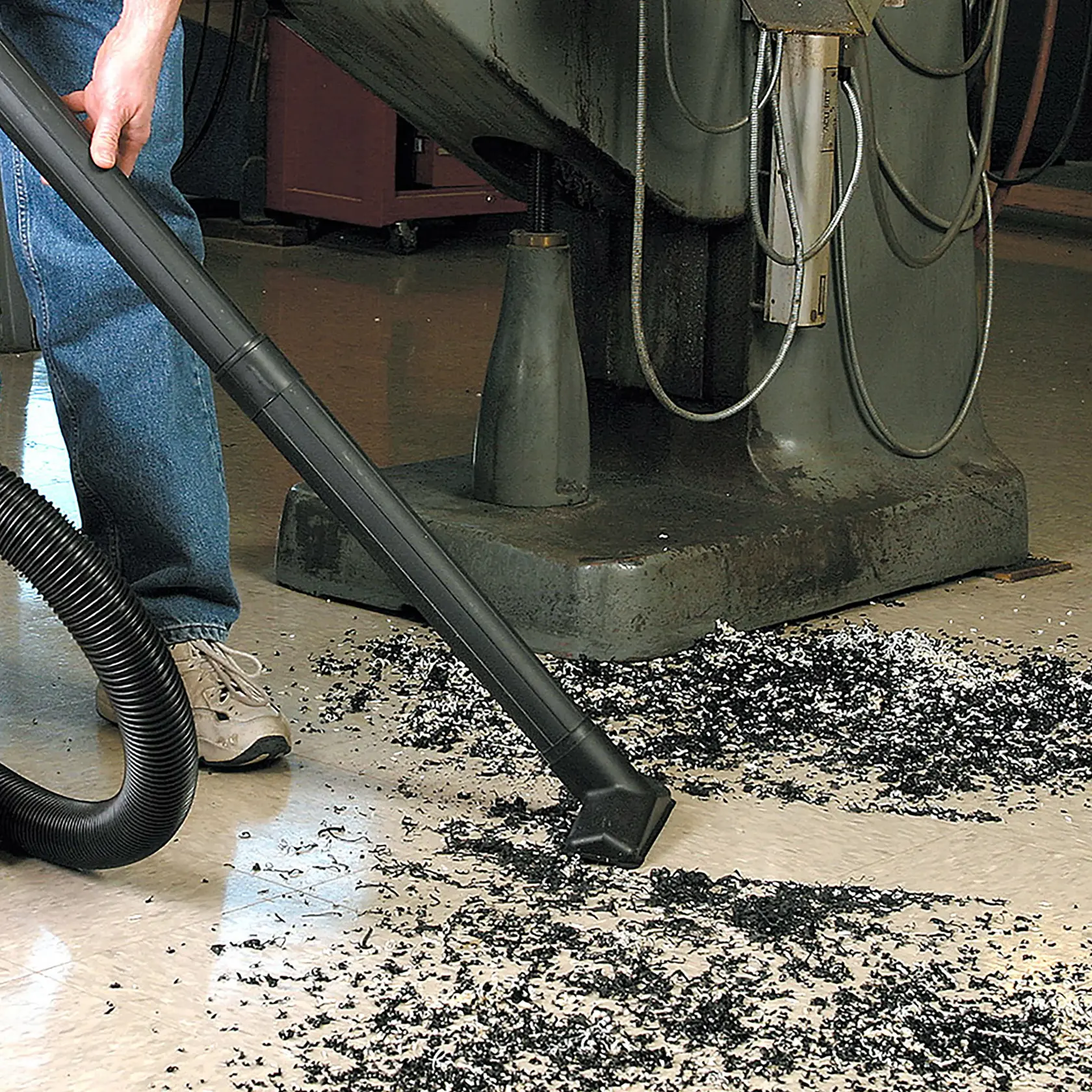 Photo of Craftsman wet/dry vacuum cleaning debris, SKU CMXZVBE38606, used on workshop floor near machine.