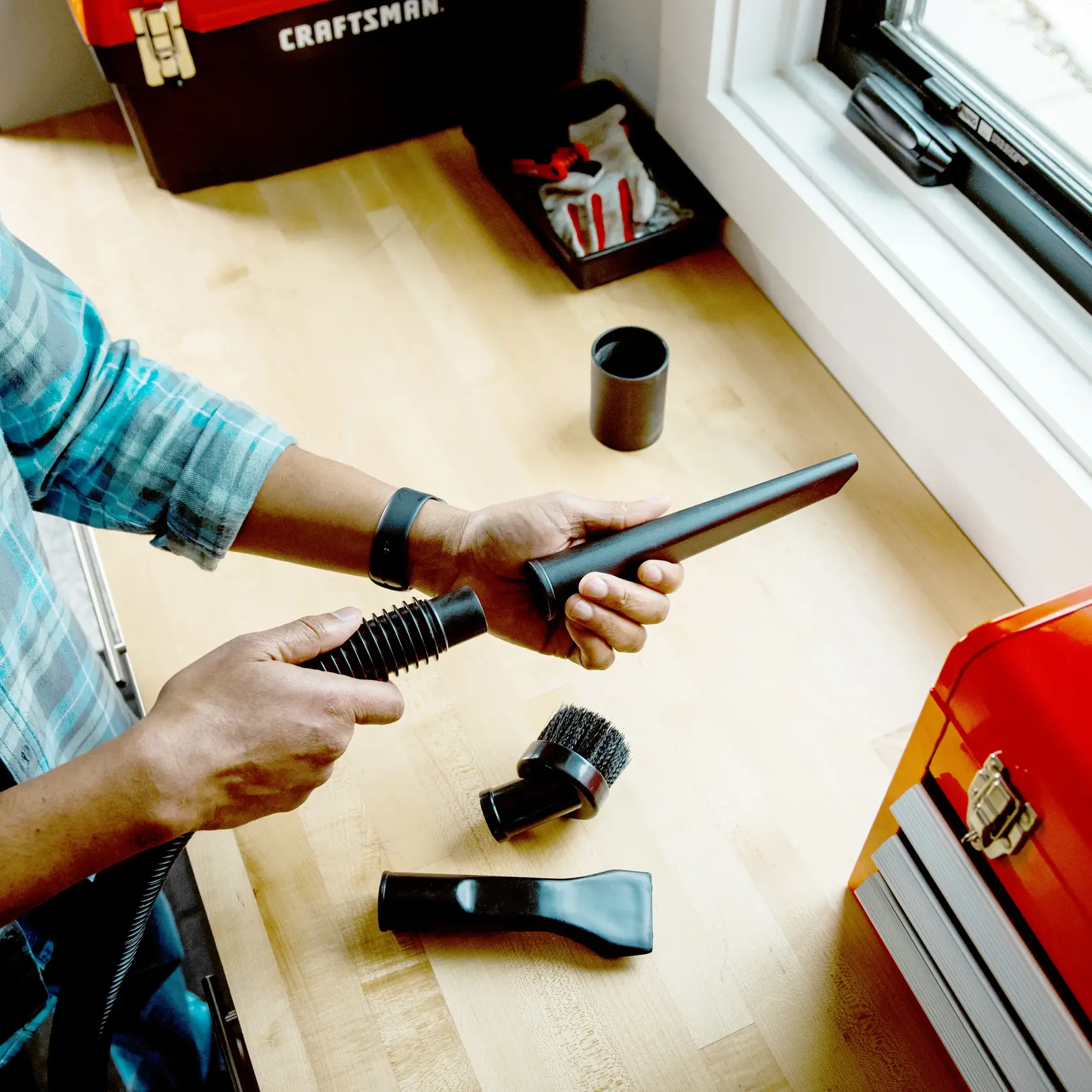 Photo of Craftsman vacuum accessories kit SKU CMXZVBE38662 on a workbench, parts include nozzle, brush, connector.