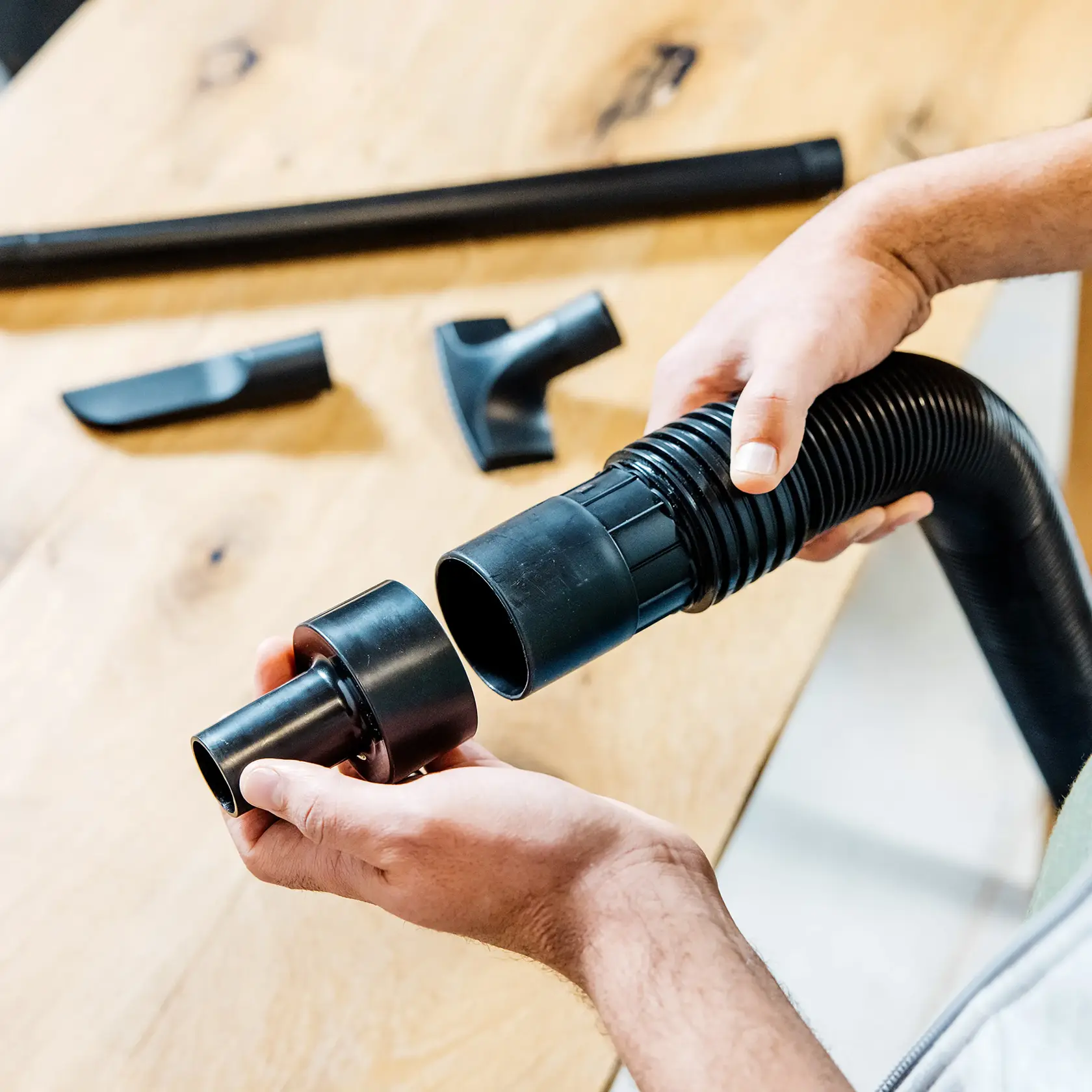Person connecting the CRAFTSMAN  Adapter to end of a 2-1/2 inch vac hose 