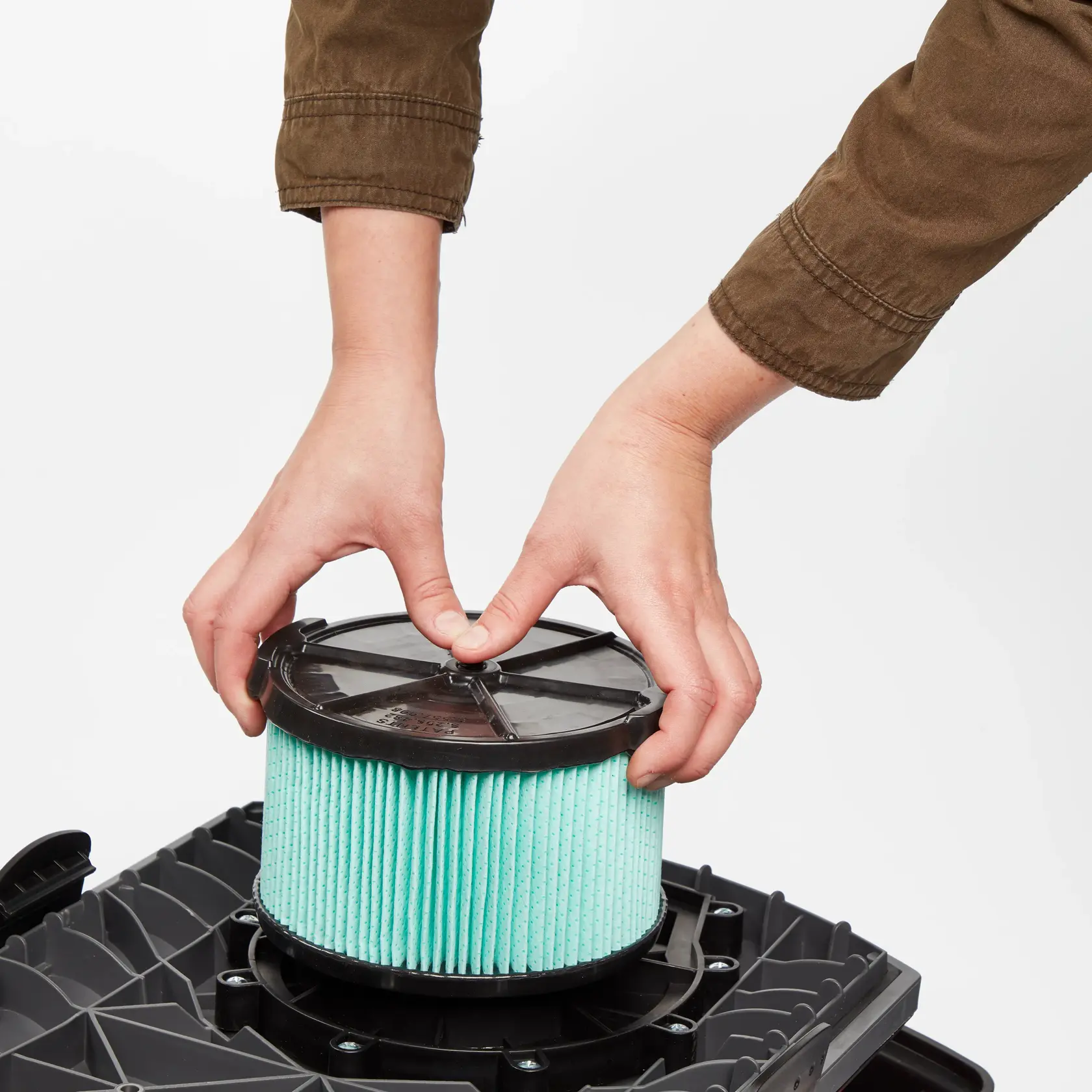 Man installing a CRAFTSMAN 1/2 Height HEPA Media Wet/Dry Vac Filter on a 3-4 CRAFTSMAN Gal Shop Vac