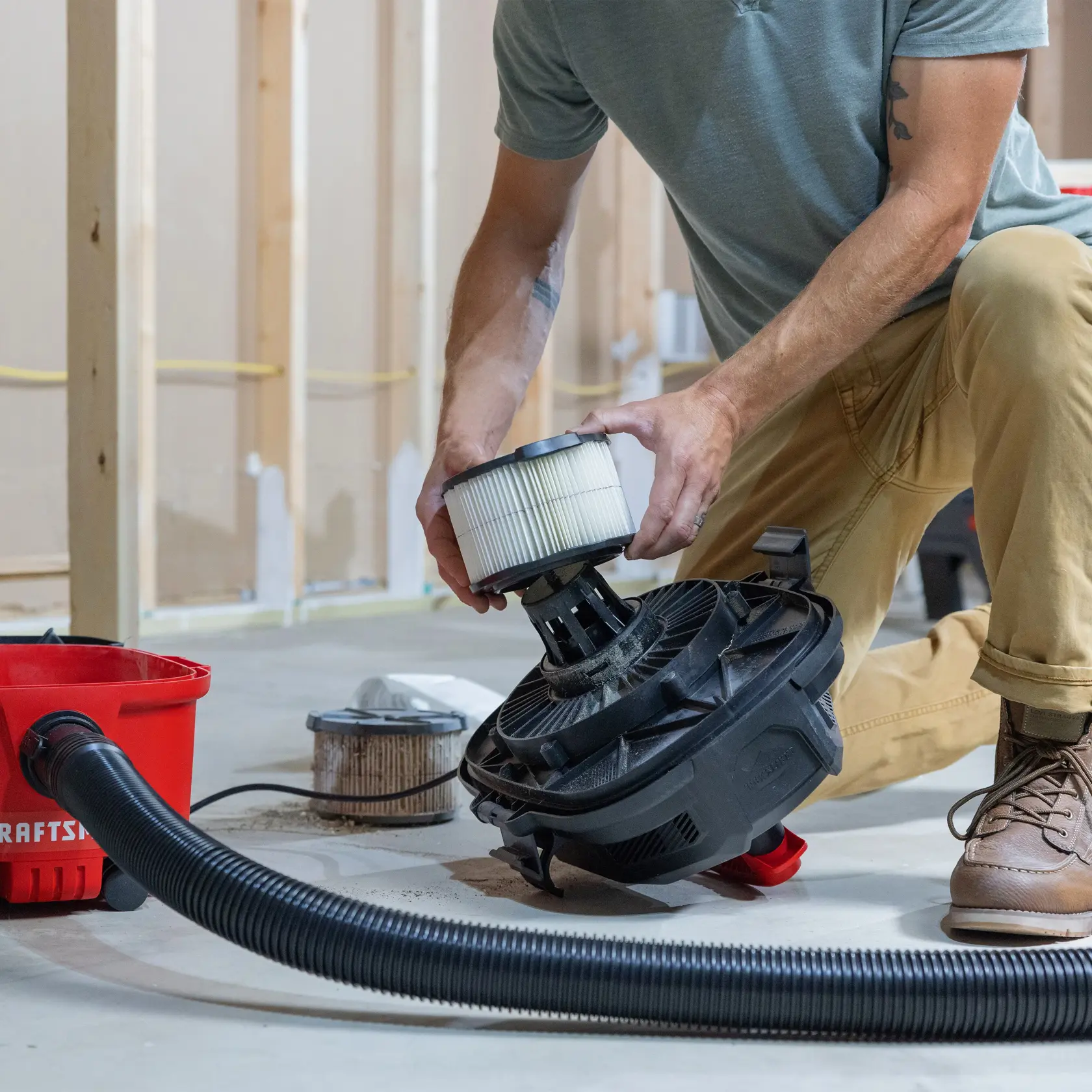 Person installing CRAFTSMAN 1/2 Height General Purpose Wet/Dry Vac Filter on a vac