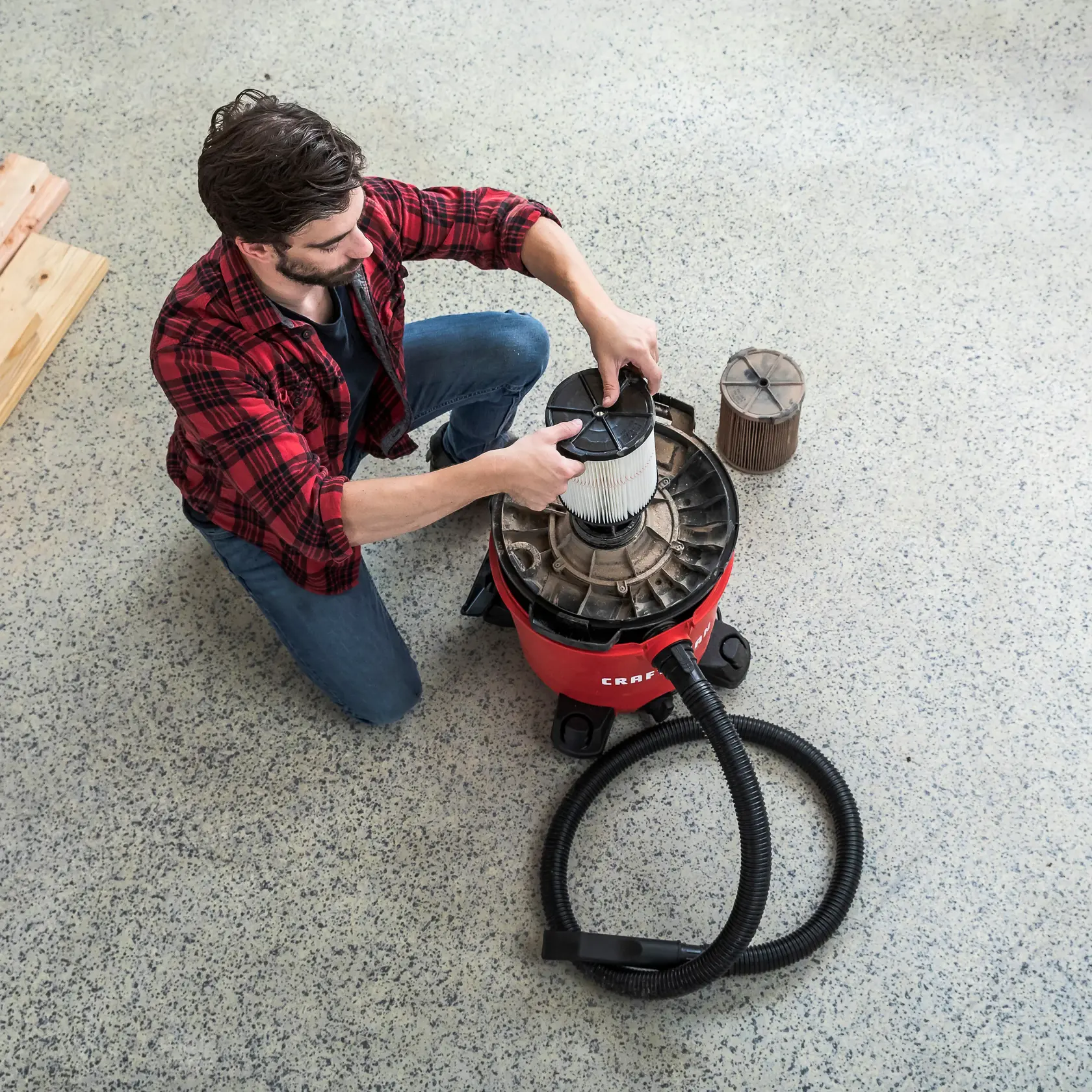 Person replacing dirty CRAFTSMAN General Dirt Replacement Filter on vac lid upside down on drum